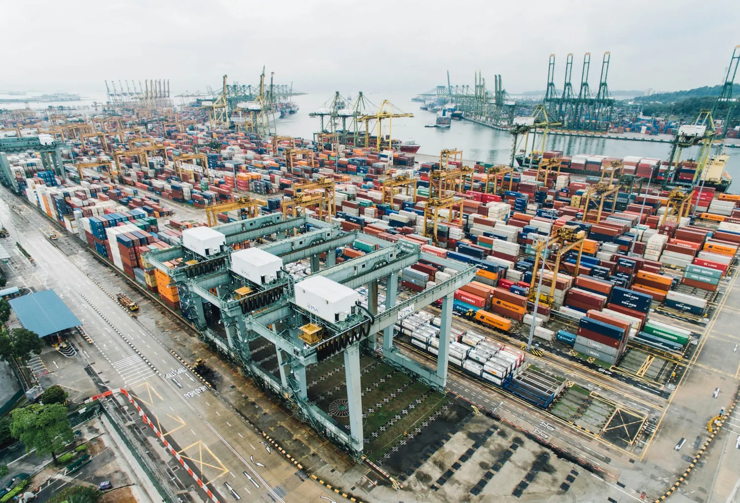 Aerial view of a container terminal with stacked freight containers and gantry cranes