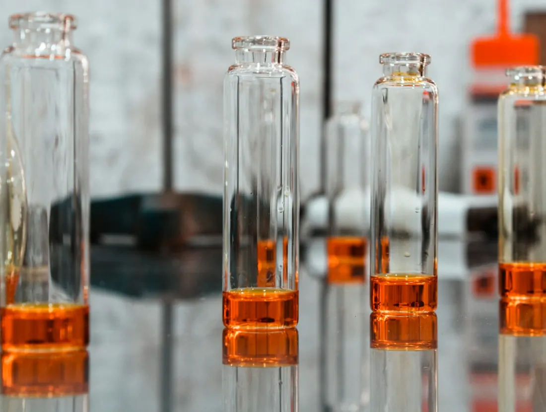 Glass vials of amber liquid on a production bench
