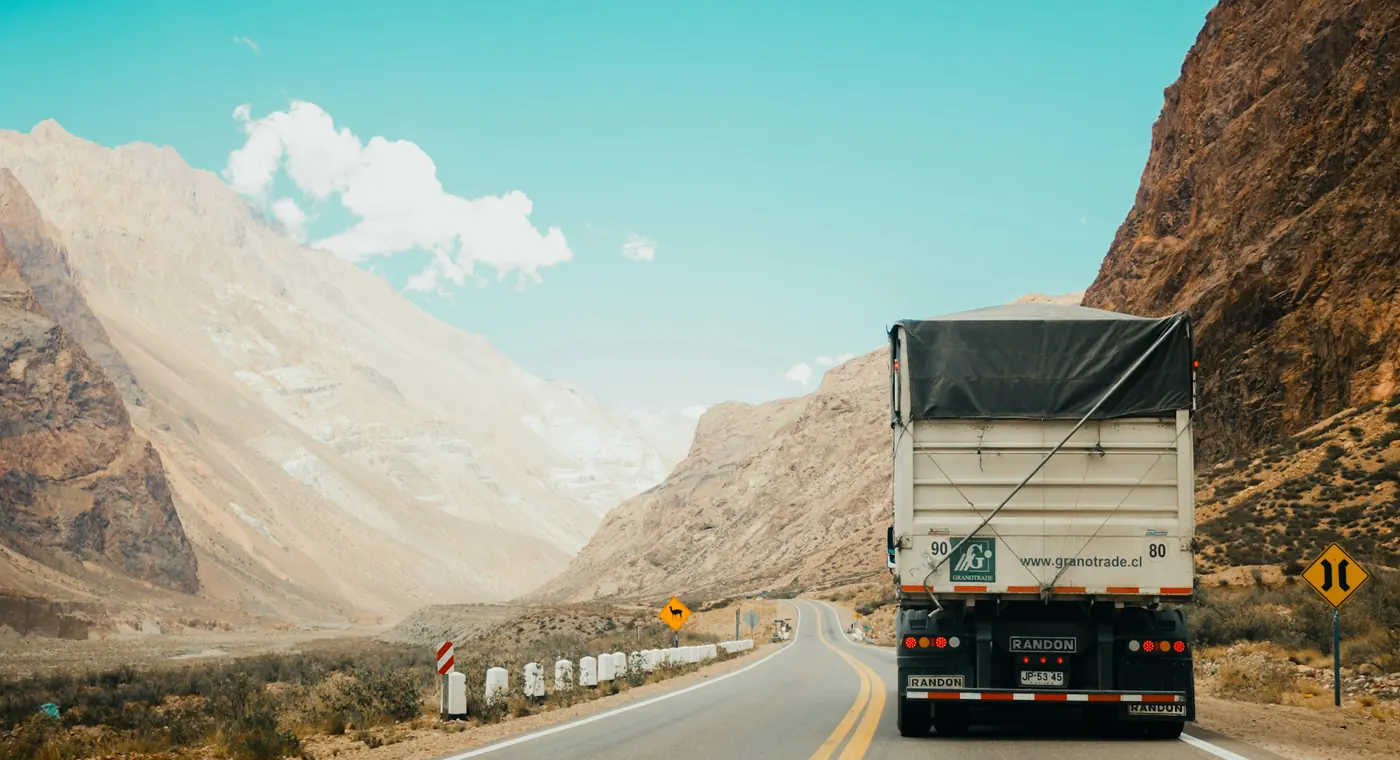 Curtain-sided freight truck on a mountain road
